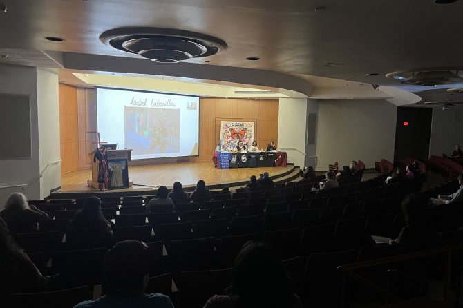 Personas toman sus asientos para escuchar a las presentaciones.