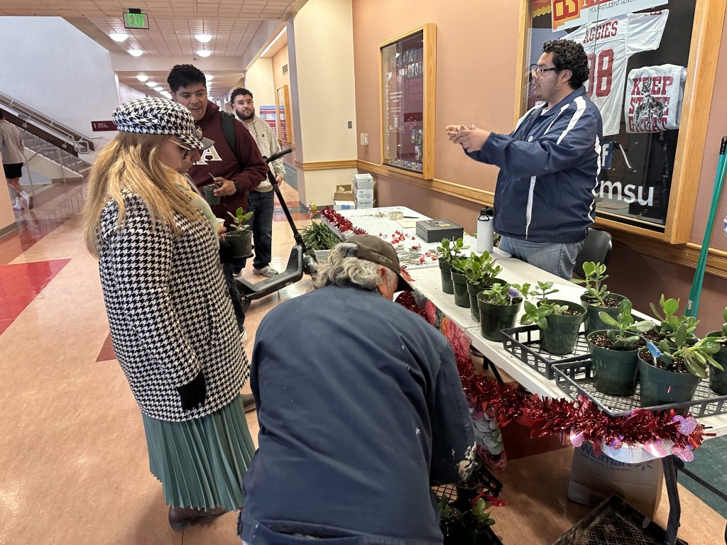 Angel Torres talking to customers at Valentine's Plant Sale.