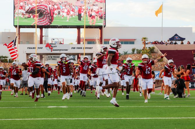 The NMSU football team runs out to the field ahead of its matchup with Bryant. (Photo/Gabriel Katko)